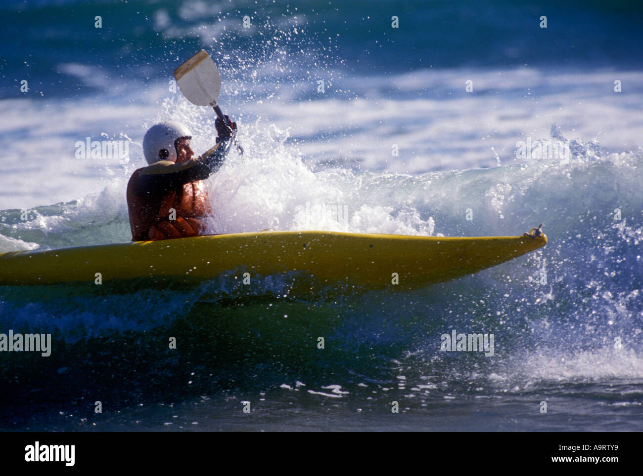 Kayaker paddling attraverso le onde del mare. Foto Stock