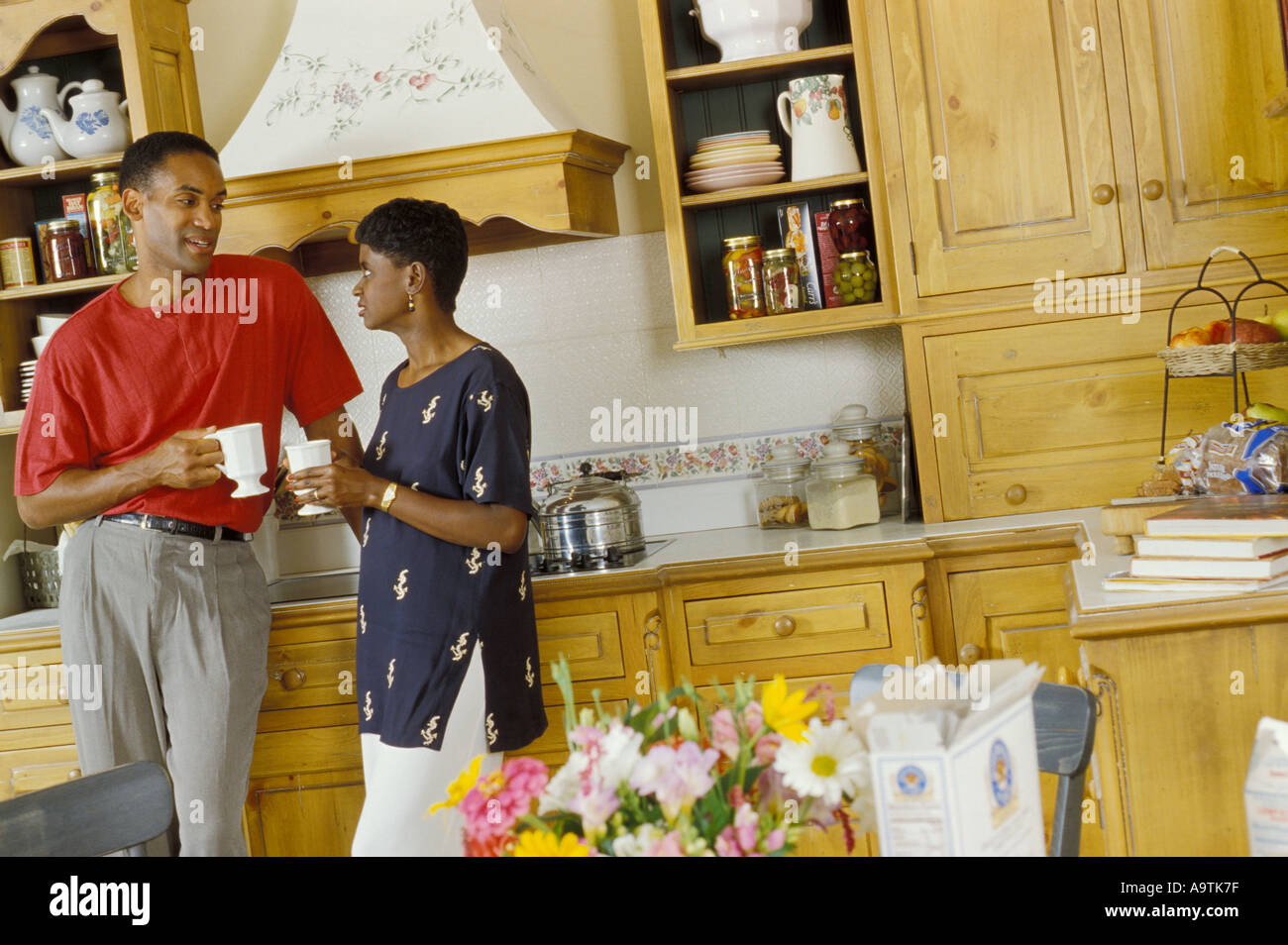 Giovani Afro American giovane in cucina parlando a colazione la mattina caffè Foto Stock