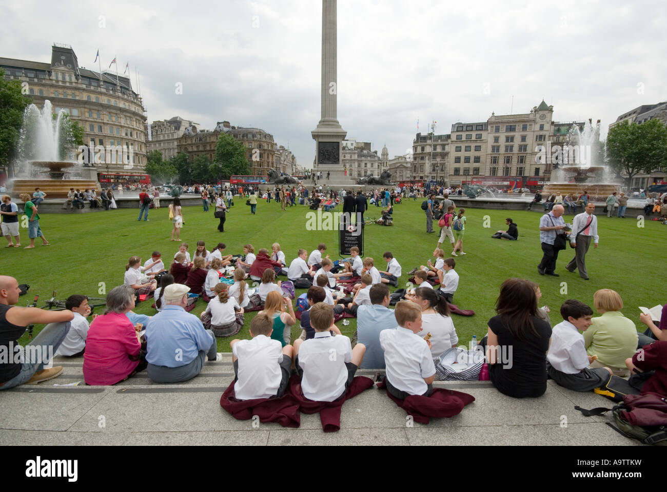 Persone a Trafalgar Square Londra prevista come un prato per promuovere Village London Foto Stock