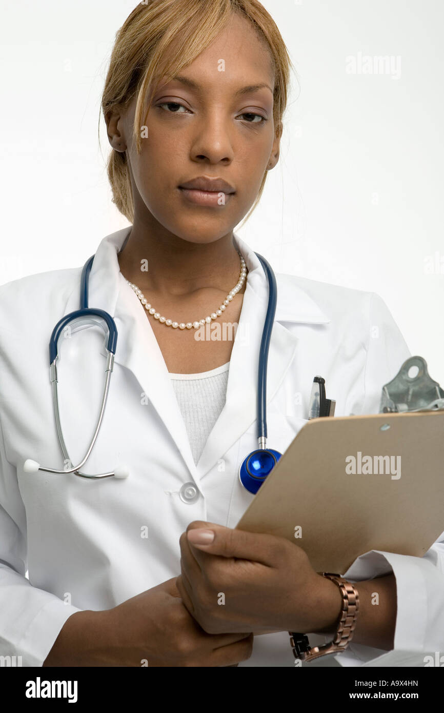 Giovani donne medico in camice bianco con un blocco appunti e uno stetoscopio prendono in seria considerazione la fotocamera Foto Stock