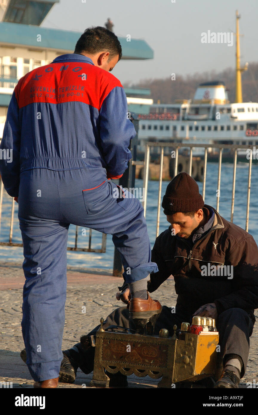 Uomo in una caldaia suit avente le sue scarpe splenduto vicino al mercato del pesce nella zona di Beyoglu di Istanbul, Turchia Foto Stock
