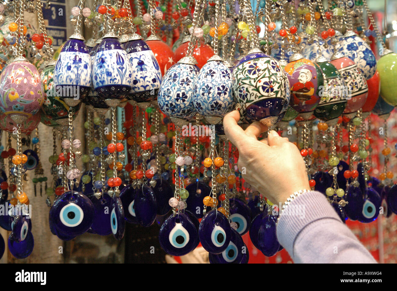 Tourist studiando ornamenti per la vendita nel grand bazaar, Istanbul Turchia Foto Stock