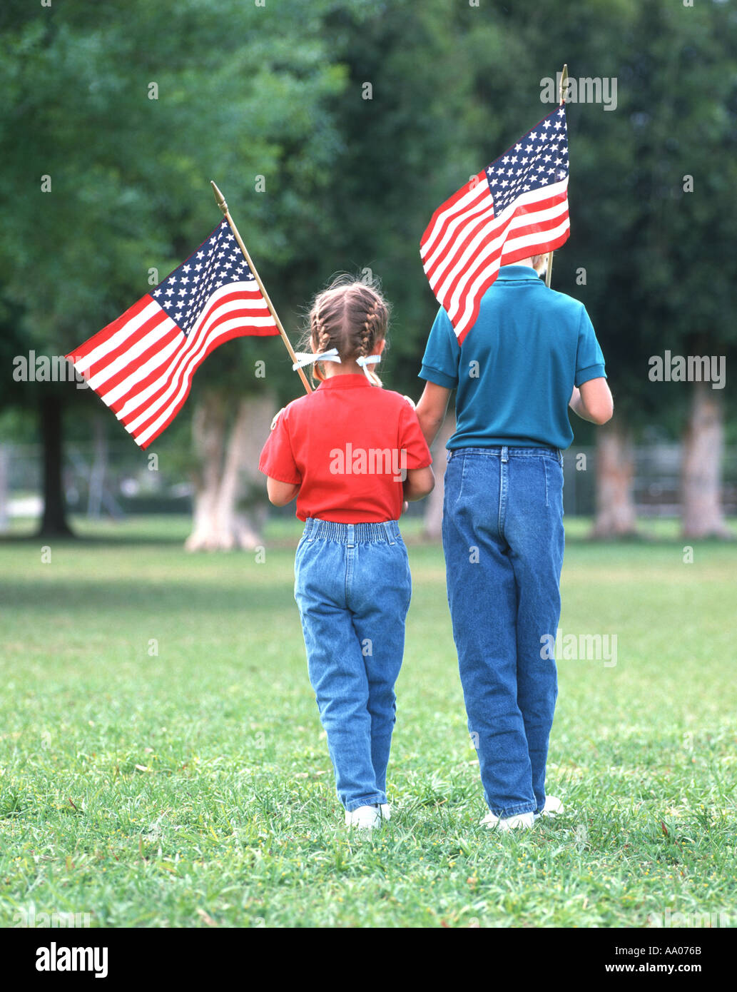 Due piccole sorelle passeggiate nel parco con bandierine americane per festeggiare la libertà NEGLI STATI UNITI Foto Stock