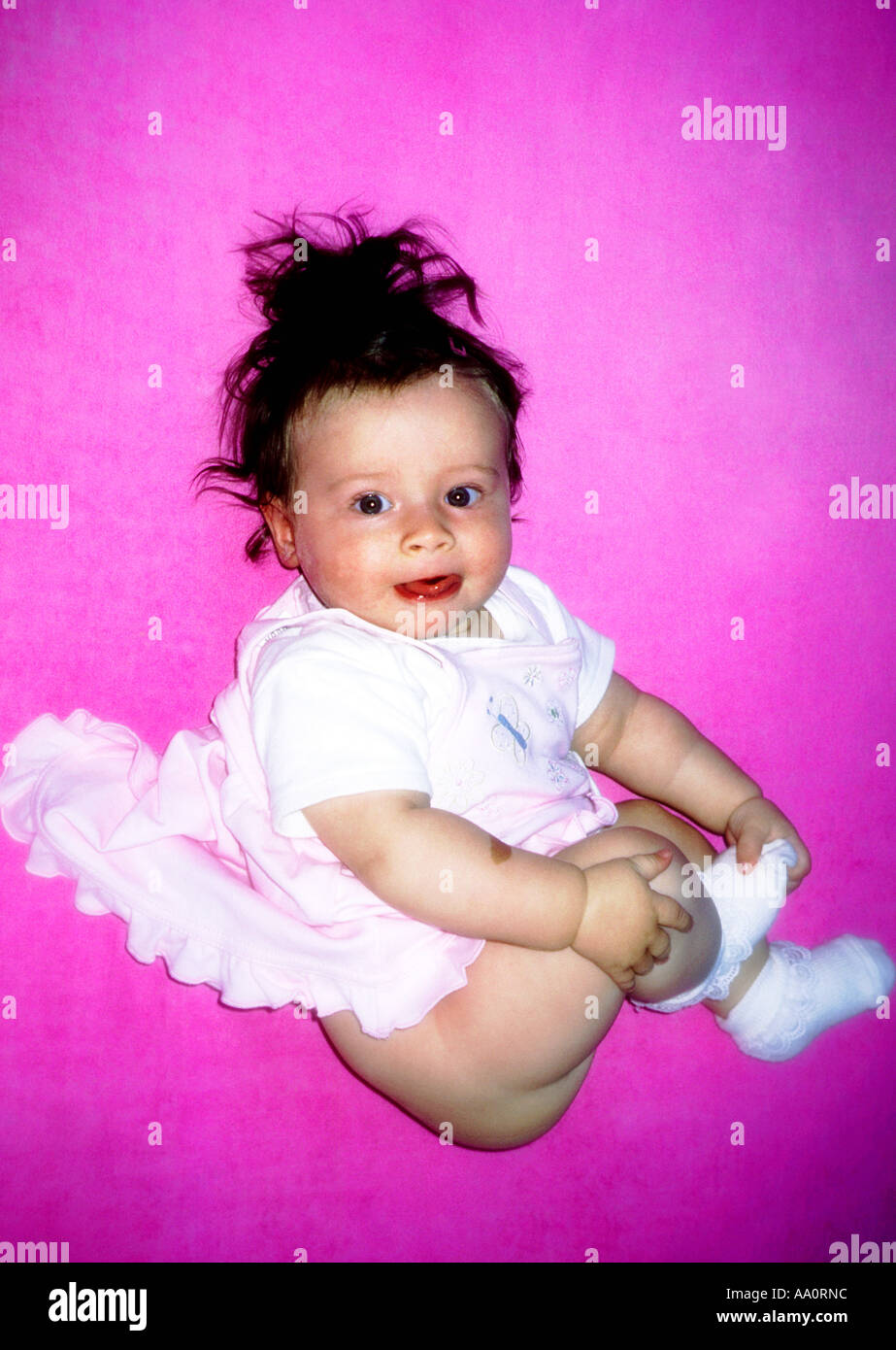 La Polonia, Baby girl (6-9 mesi) su sfondo rosa Foto Stock