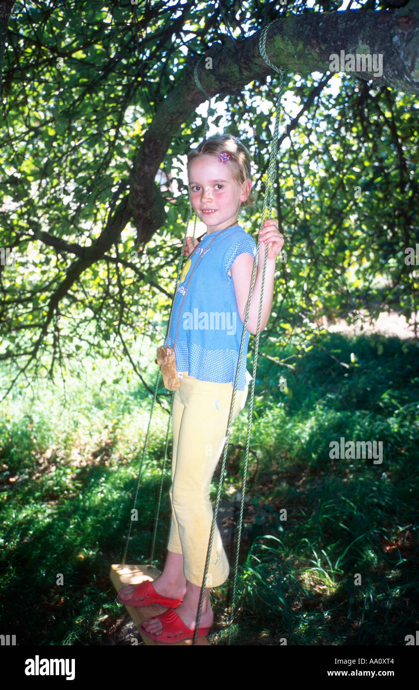 Polonia, Uniejow, ragazza (6-7) in piedi su swing, ritratto Foto Stock