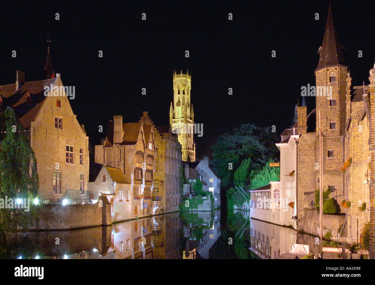 Canale vicino al mercato del pesce di notte con il Belfort nella distanza, Bruges, Belgio Foto Stock
