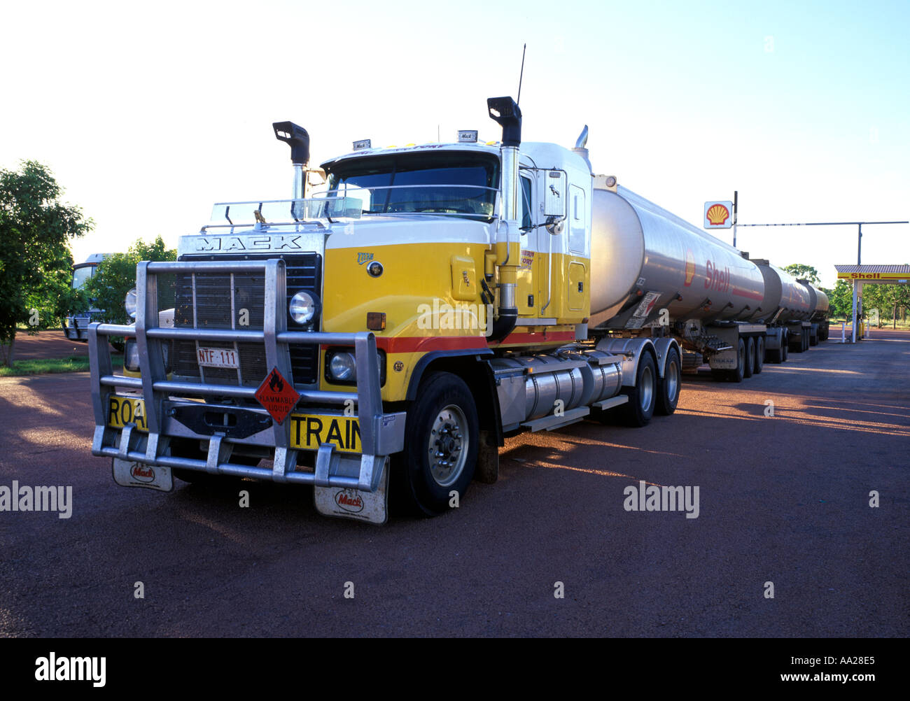 Un treno su strada in corrispondenza di una stazione di Shell nell'outback Australia Foto Stock