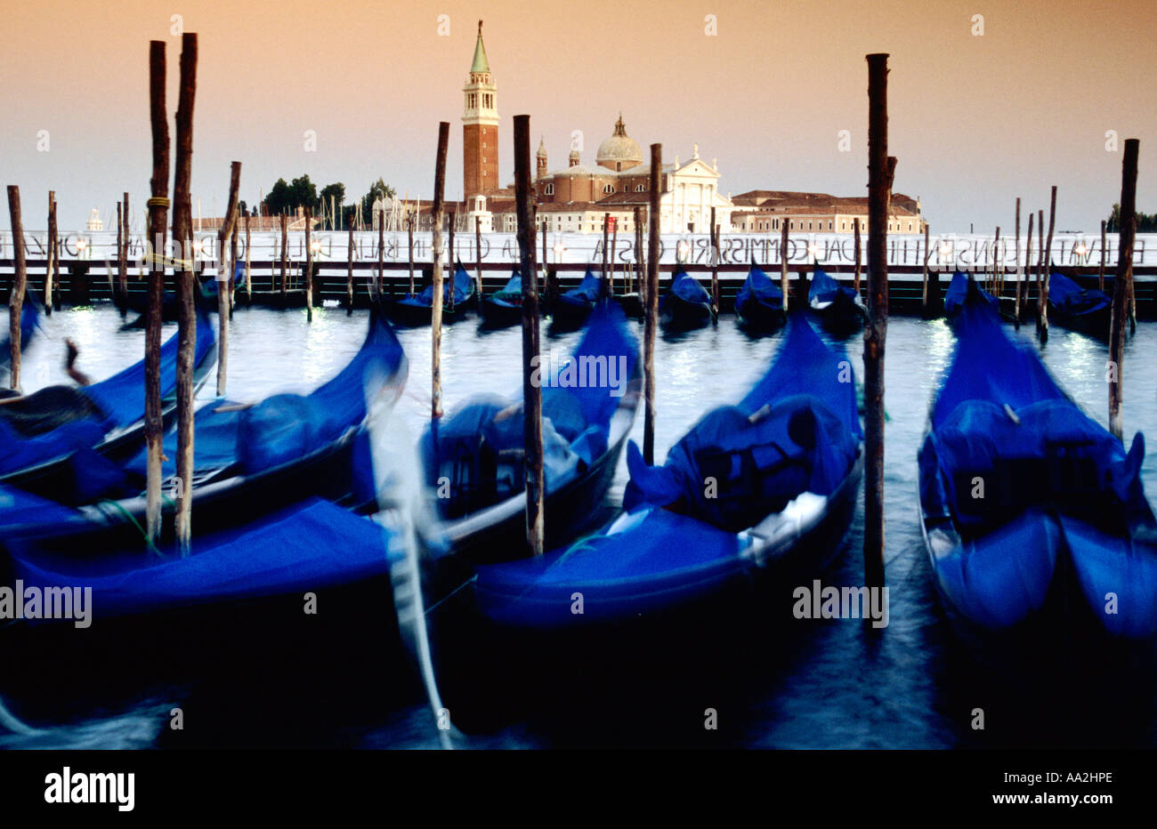 L'Italia, Venezia, offuscata gondole e San Giorgio Maggiore isola e chiesa al crepuscolo, blu gondole attraccate Foto Stock