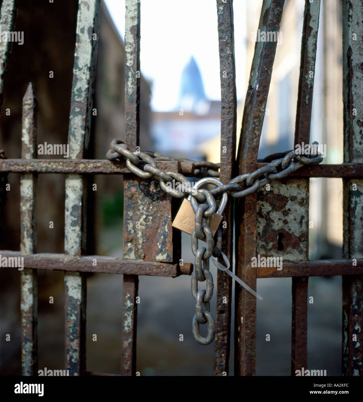 Una catena e bloccato cancello di ferro in Brick Lane guardando attraverso il Gherkin edificio nella zona est di Londra UK KATHY DEWITT Foto Stock
