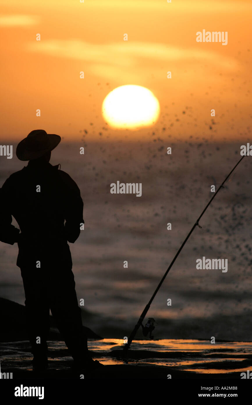 Fisherman la visione di Sun l'impostazione della Nuova Zelanda Foto Stock