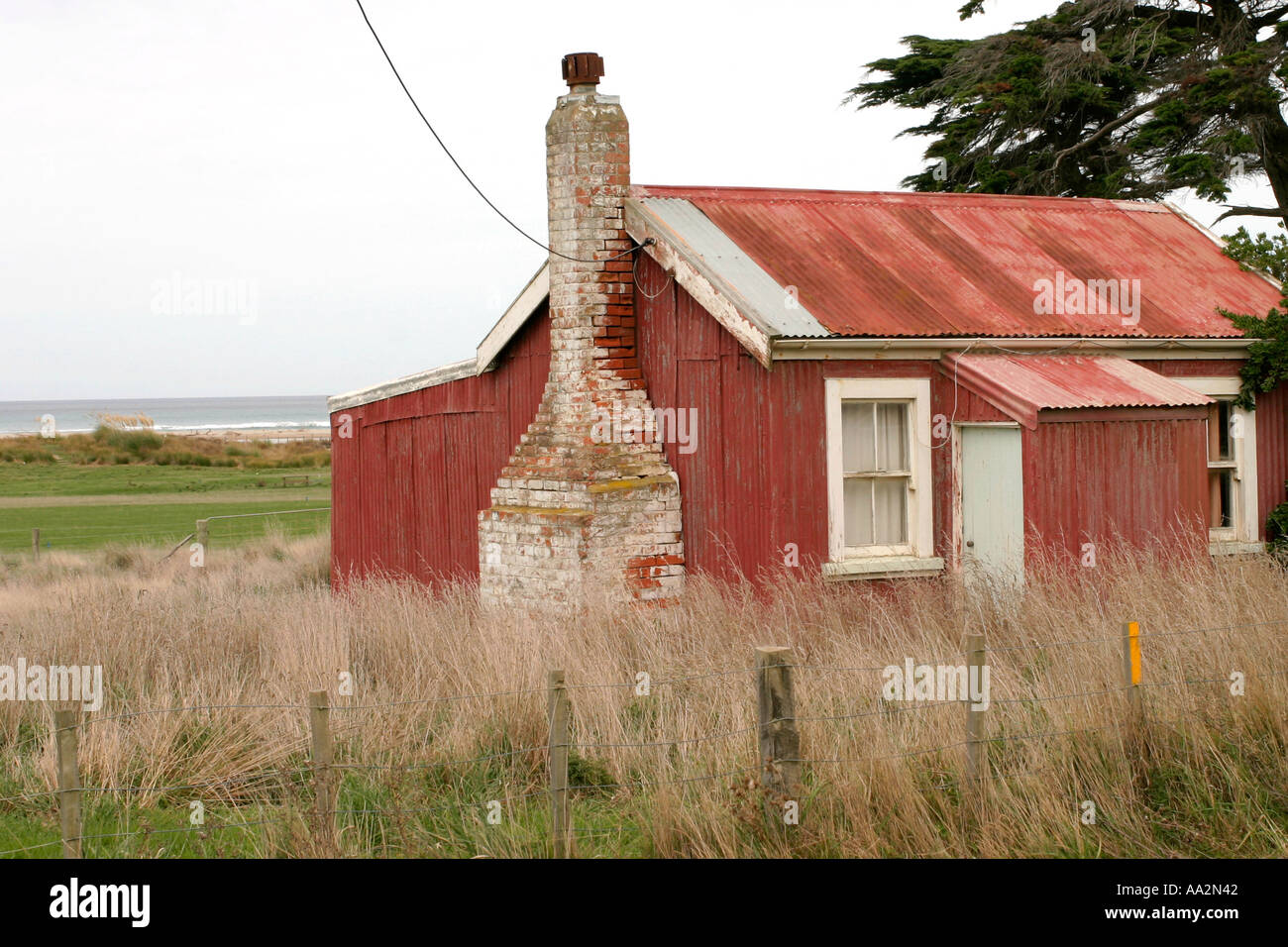 Vecchia a lato della spiaggia cottage Nuova Zelanda Foto Stock