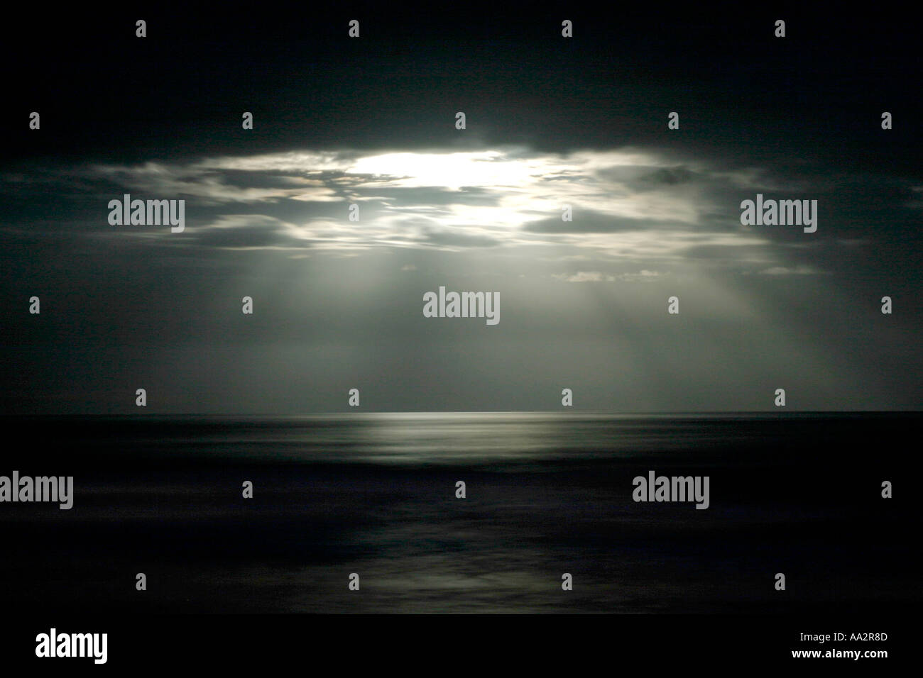 I raggi della luna rottura attraverso le nuvole oltre oceano la Nuova Zelanda Foto Stock