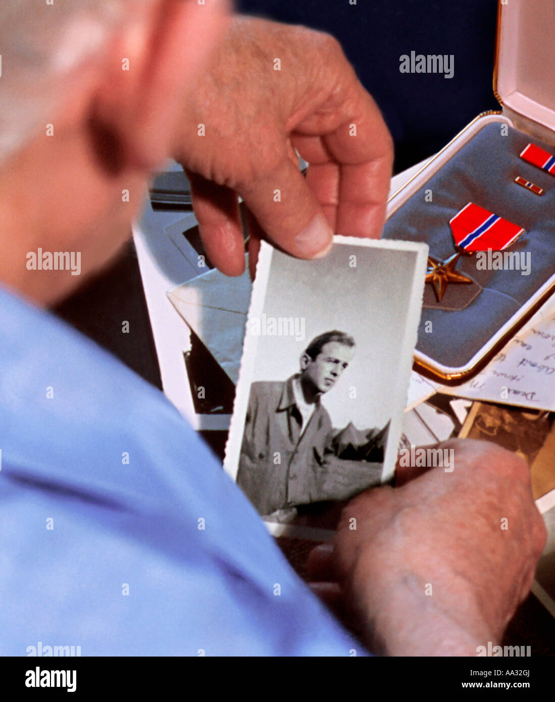 Medaglia di guerra veterano. Veterano anziano degli Stati Uniti che guarda una fotografia di se stesso come un giovane soldato. Medaglia di bronzo della seconda guerra mondiale Foto Stock