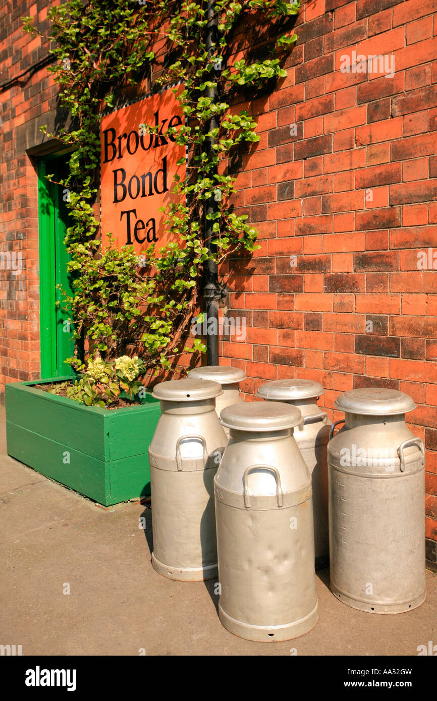 Vecchio bidoni per il latte e tè pubblicità alla stazione di Rothley sull'GCR Foto Stock