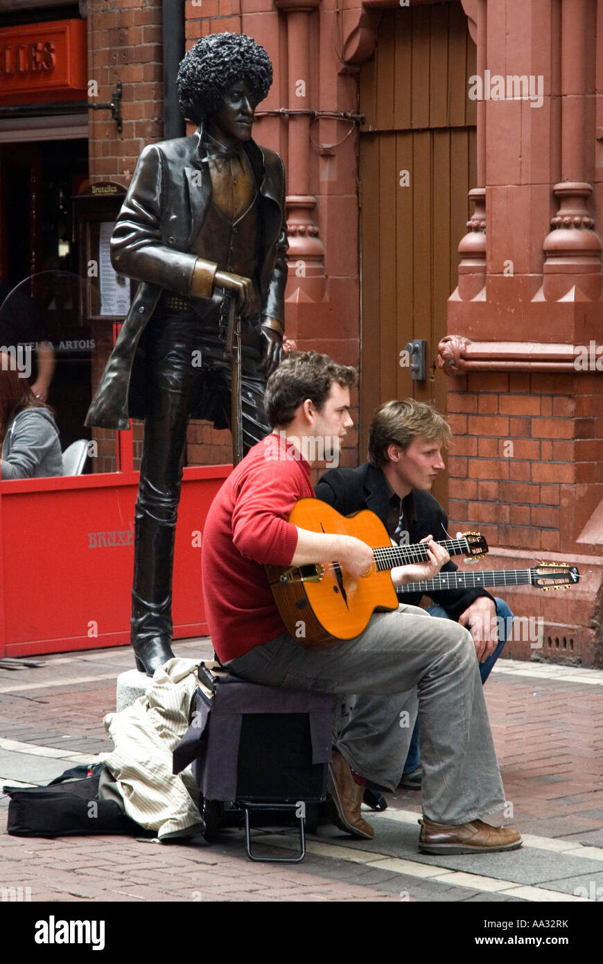 Musicista di strada accanto a Phil Lynott statua, Dublino, Irlanda Foto Stock