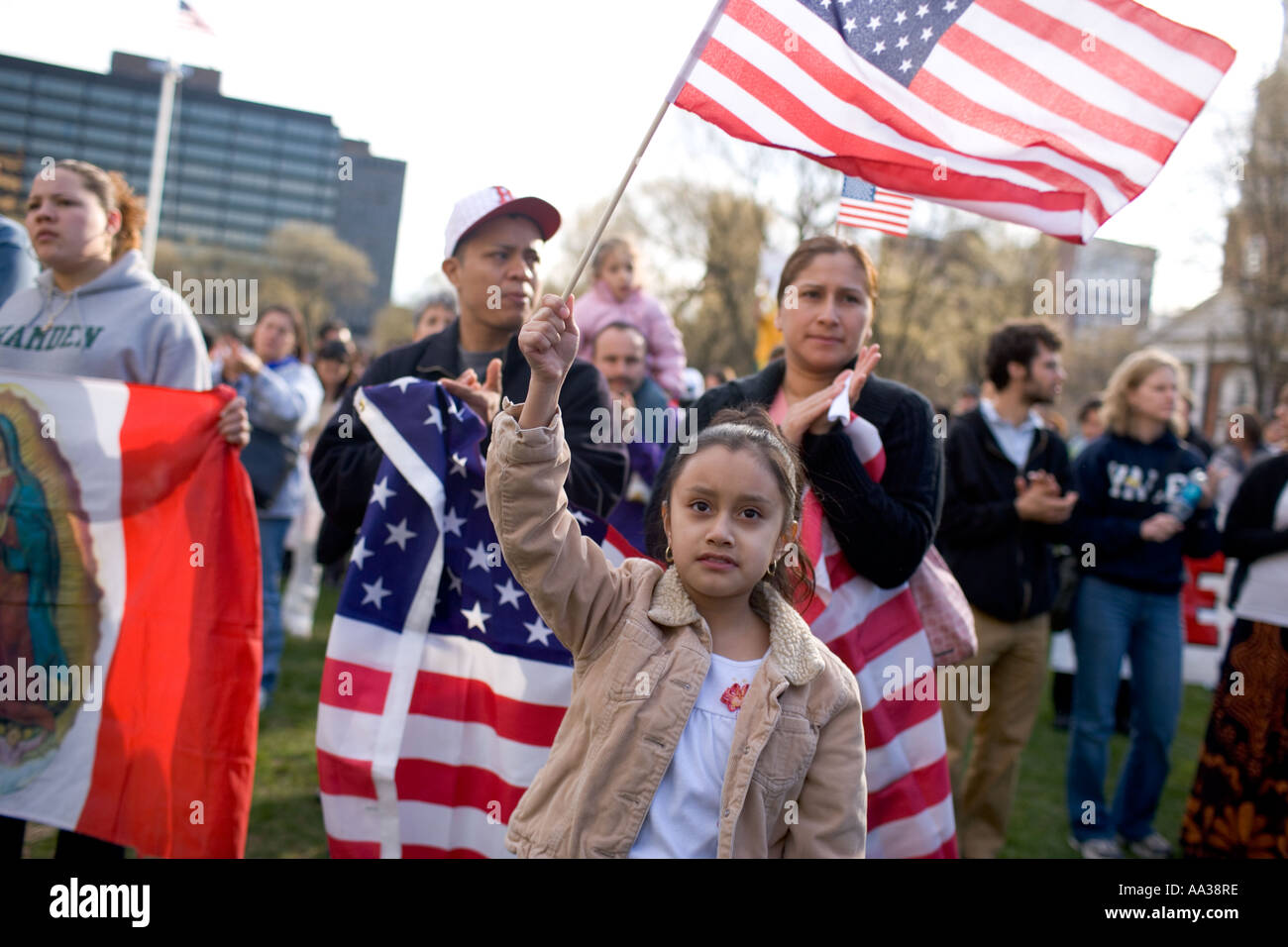Una piccola ragazza rinuncia a un flag di noi durante un Rally di immigrazione Foto Stock