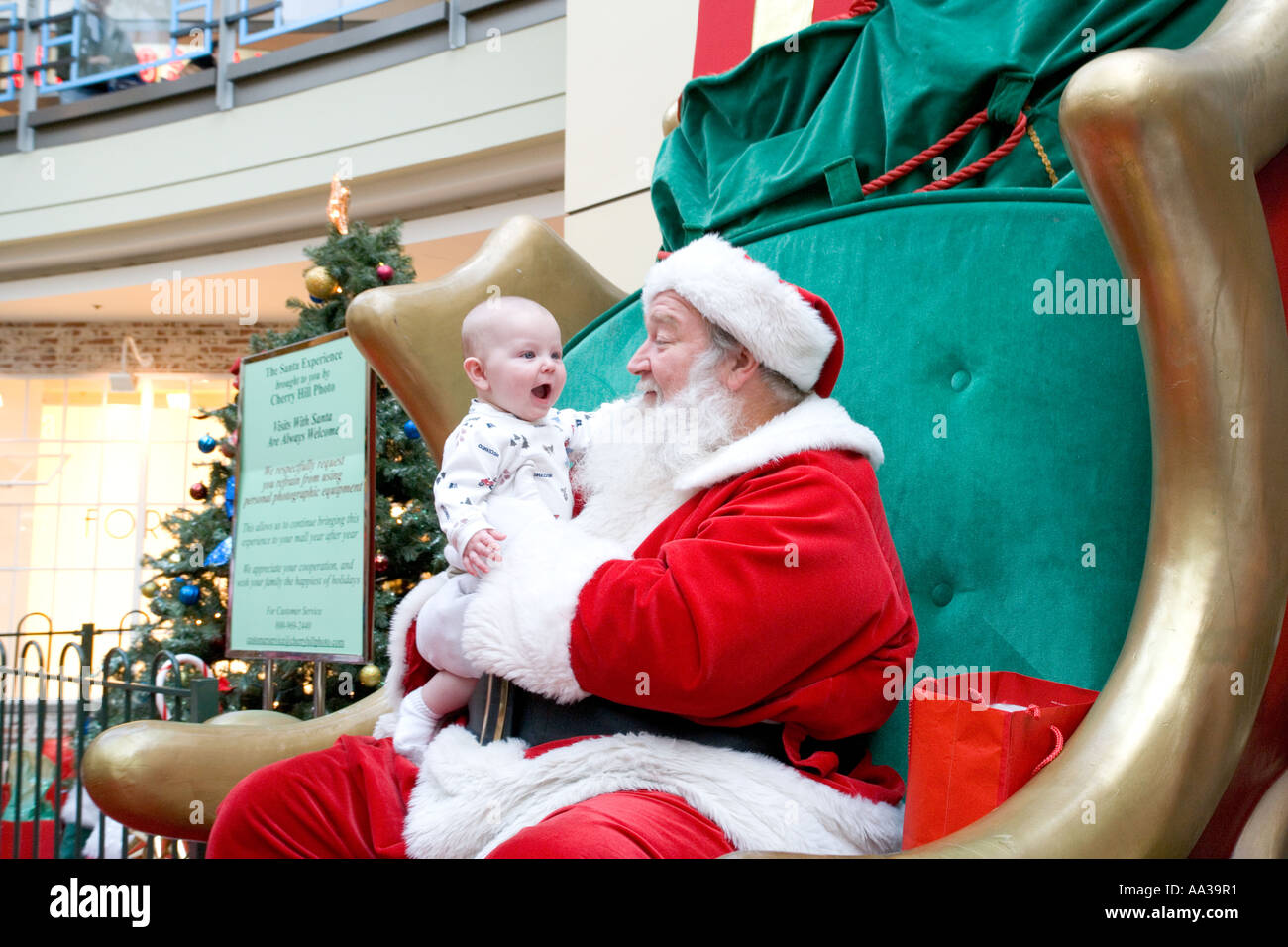 Babbo Natale in un centro commerciale con eccitato baby Foto Stock