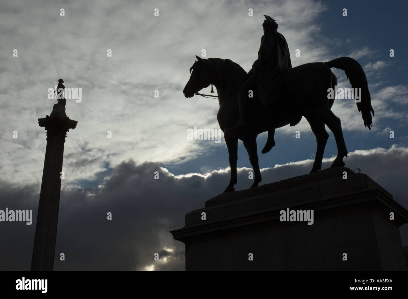 Statua di re George IV (4a) a cavallo e Nelson's colonna in silhouette Trafalgar Square London REGNO UNITO Foto Stock