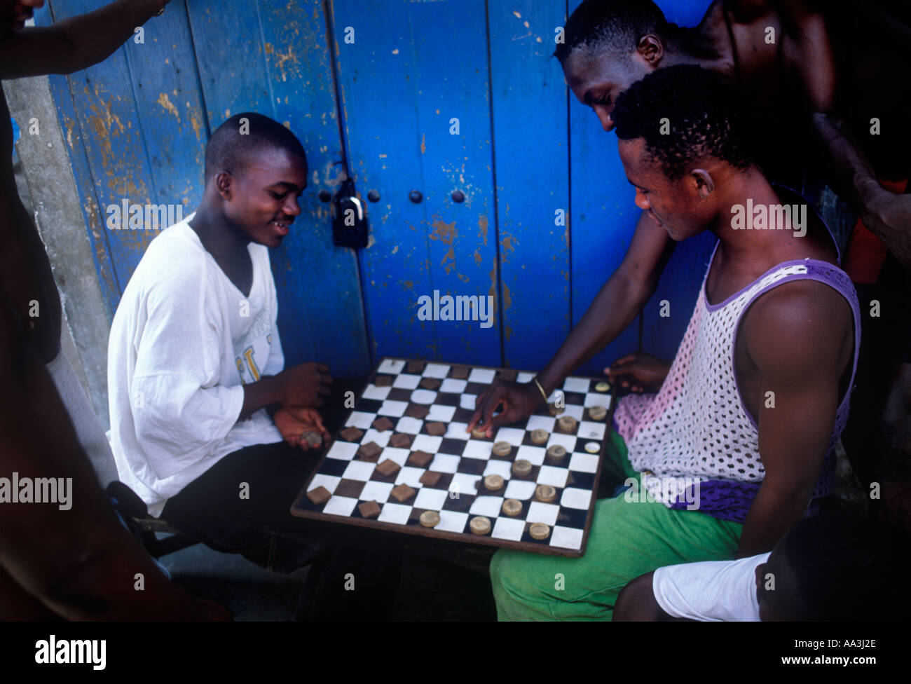 Un curioso rende il suo contributo per un gioco della dama bozze in una strada ad Accra in Ghana Africa occidentale Foto Stock