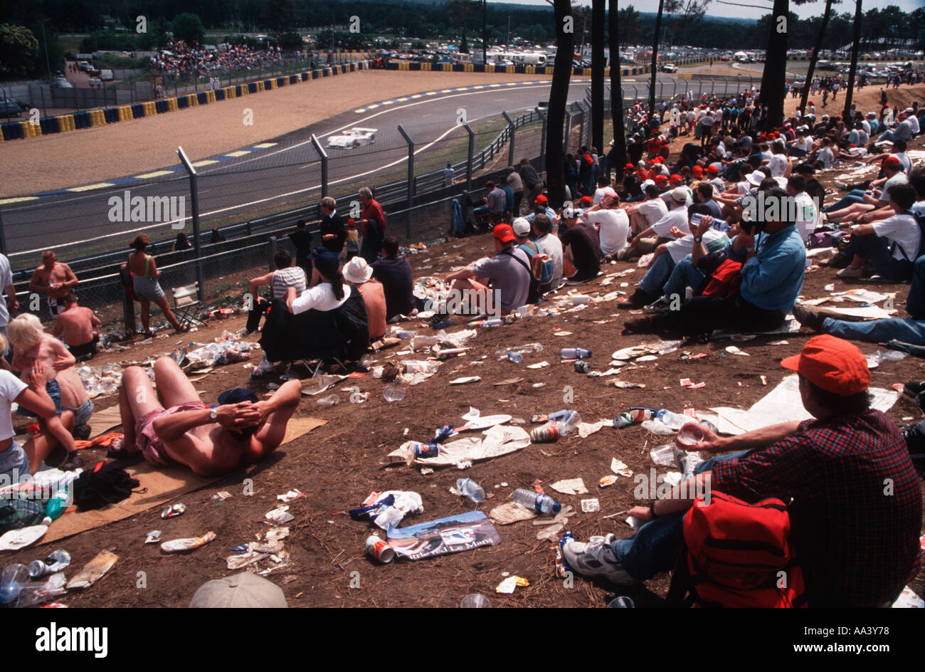 Spettatori a1997 Le Mans 24 ore di gara automobilistica seduto su di una collina tra scartato i rifiuti di bottiglie e lattine di pacchetti Foto Stock