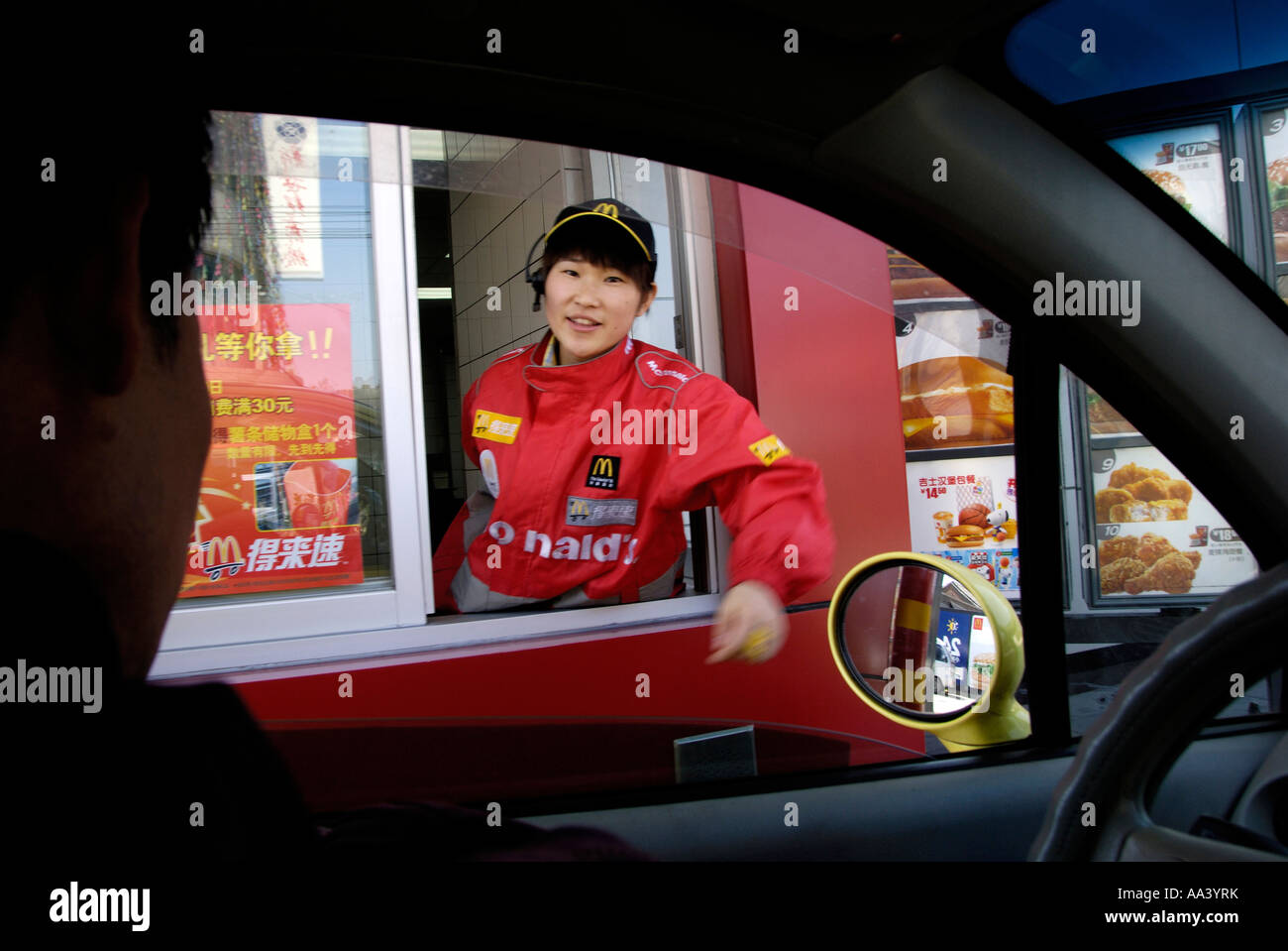 Un dipendente cinese serve un driver nel primo Sinopec McDonald drive thru a Beijing in Cina 12 APR 2007 Foto Stock