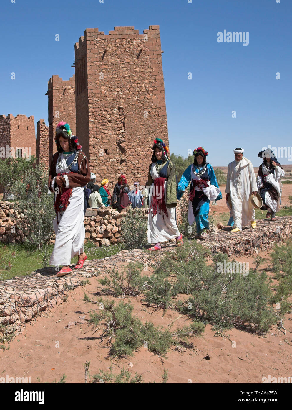 Extra film in costume camminando in file di Ait Benhaddou, Ouarzazate, Marocco, Africa del nord Foto Stock