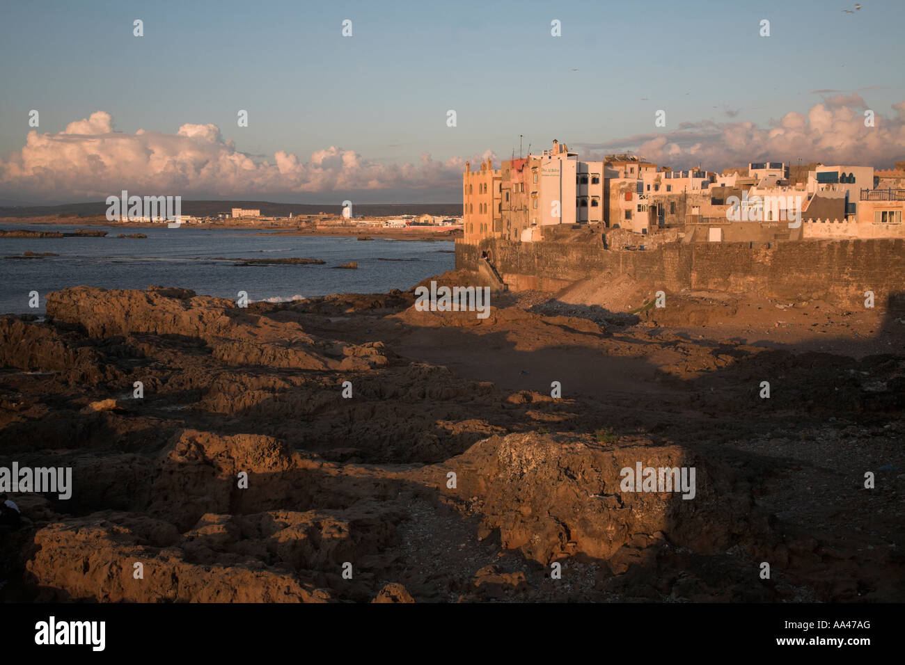 Costa rocciosa ed edifici crepuscolo Essaouira, Marocco, Africa del nord Foto Stock