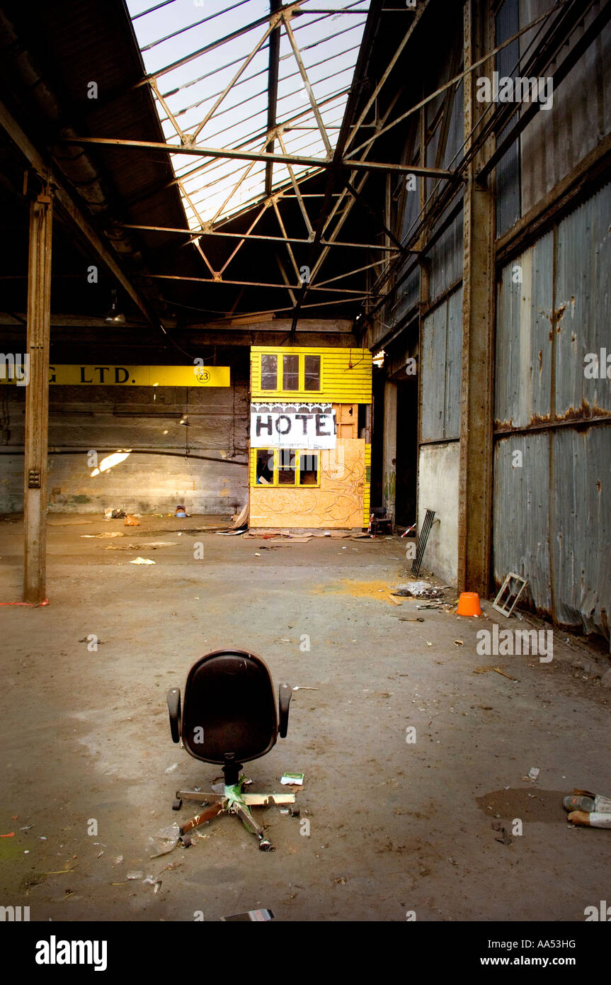 Un cartello d'hotel attaccato ad un capannone giallo in magazzino disusato da squadroni. Foto di Jim Holden. Foto Stock