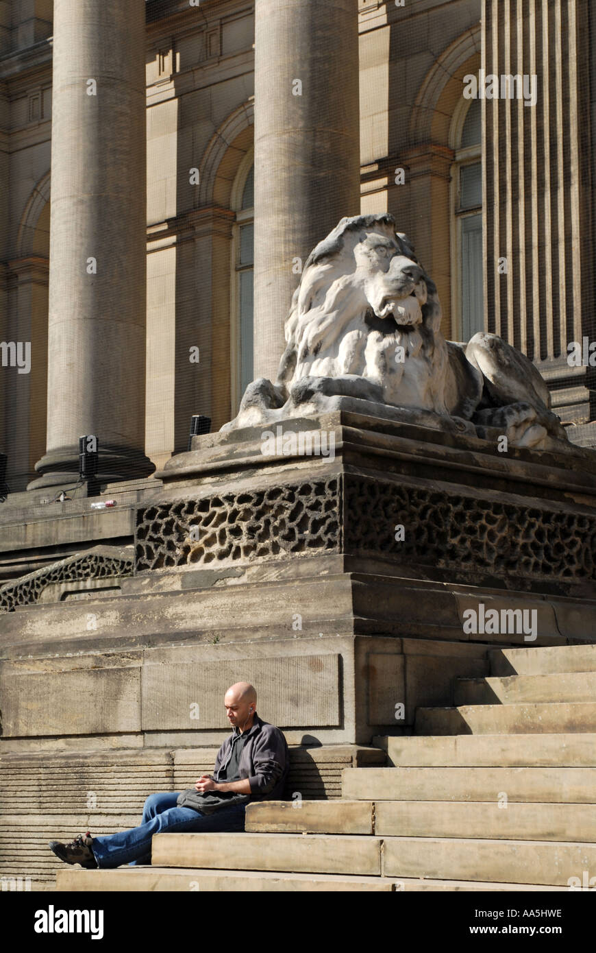 Giovane uomo di relax al sole di fronte a Leeds Town Hall Foto Stock