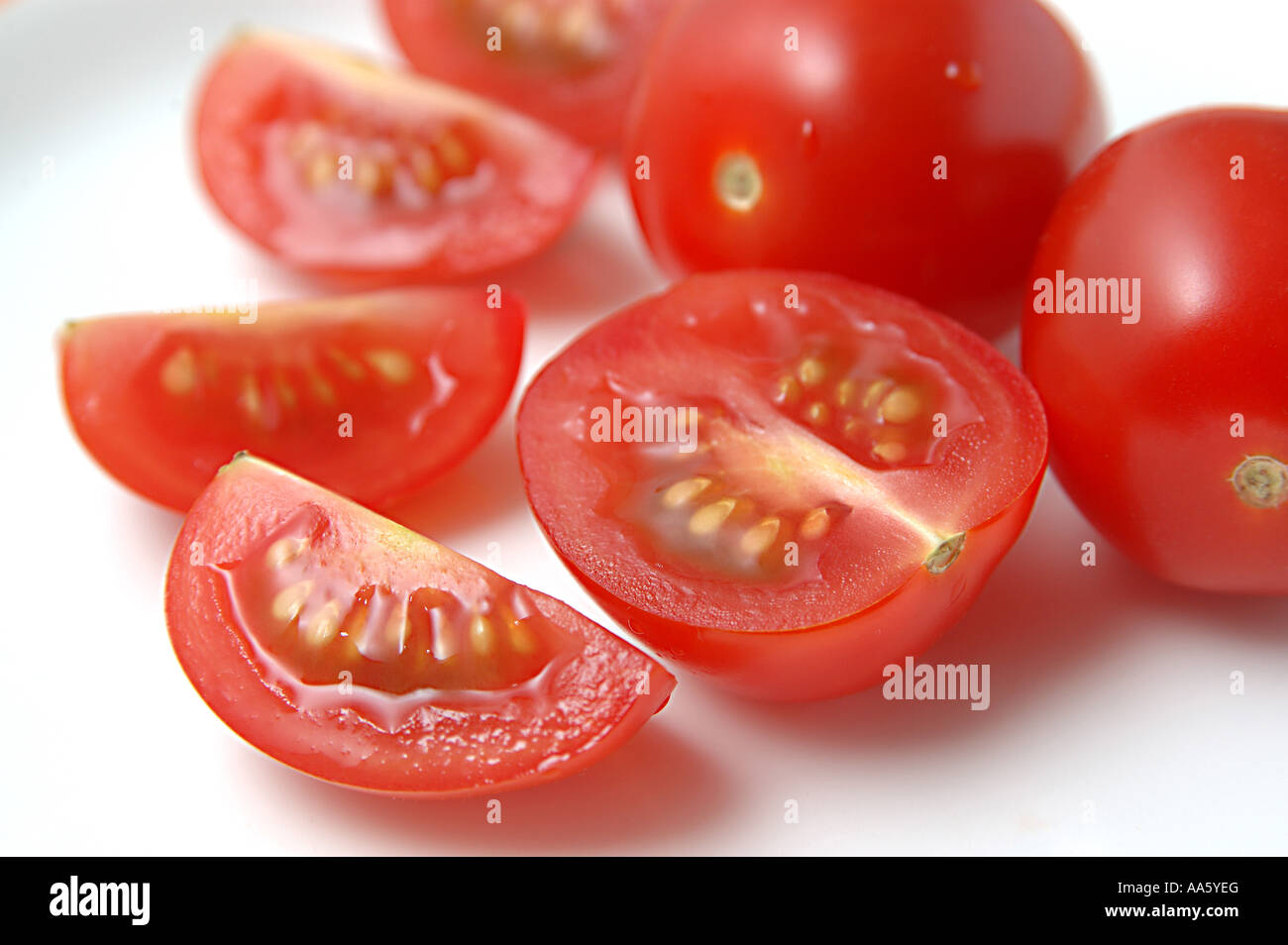 Pomodori rossi tagliati a pezzi su fondo bianco Foto Stock
