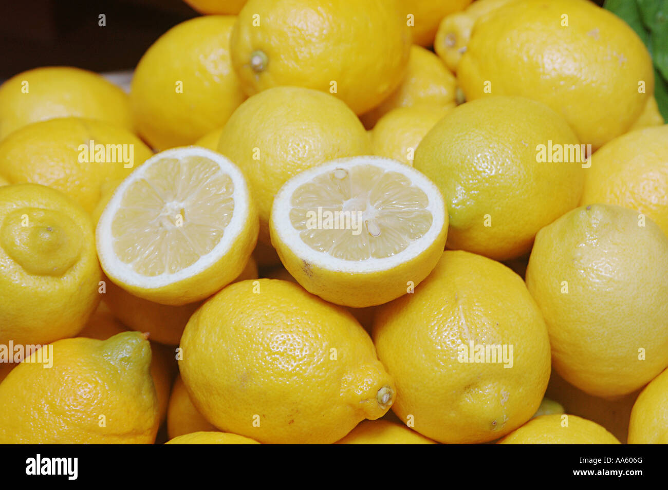 Limoni di frutta e uno tagliato in due pezzi Foto Stock
