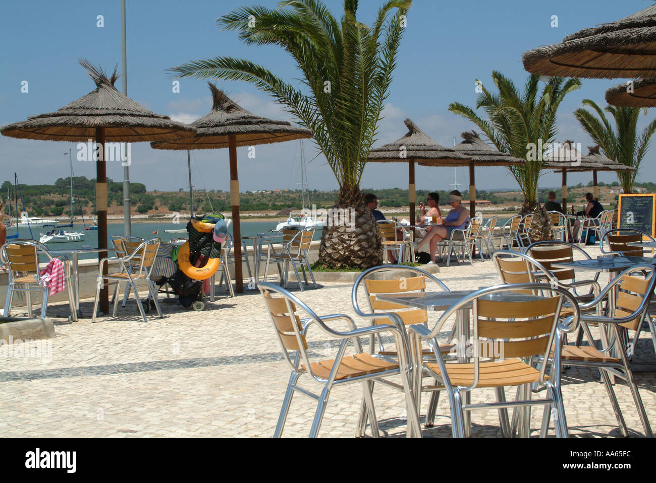 Persone gustando un drink presso il Bar e ristorante sul lungomare di Alvor Algarve Portogallo Foto Stock