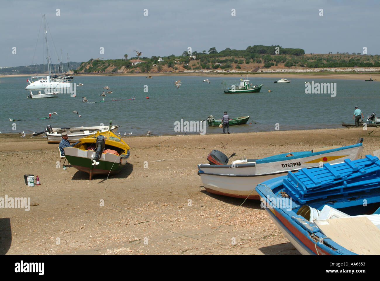 Spiaggiata e affondata barche da pesca in acqua a Alvor Città Algarve Portogallo Foto Stock