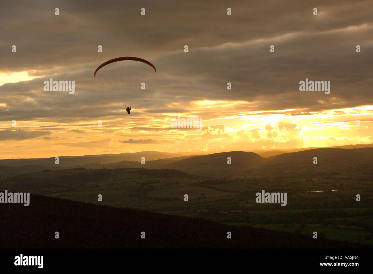 Parapendio volare verso il tramonto del Long Mynd, Shropshire Foto Stock