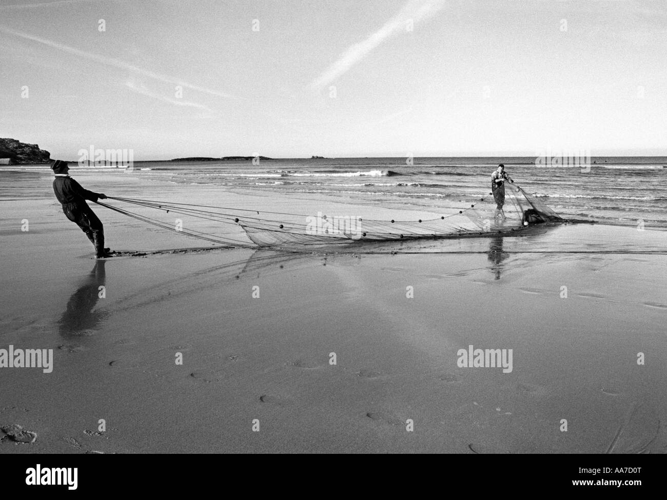 Tirare i pescatori nelle loro reti dalla marea sulla spiaggia di Sennen, Cornwall. Regno Unito. Foto Stock