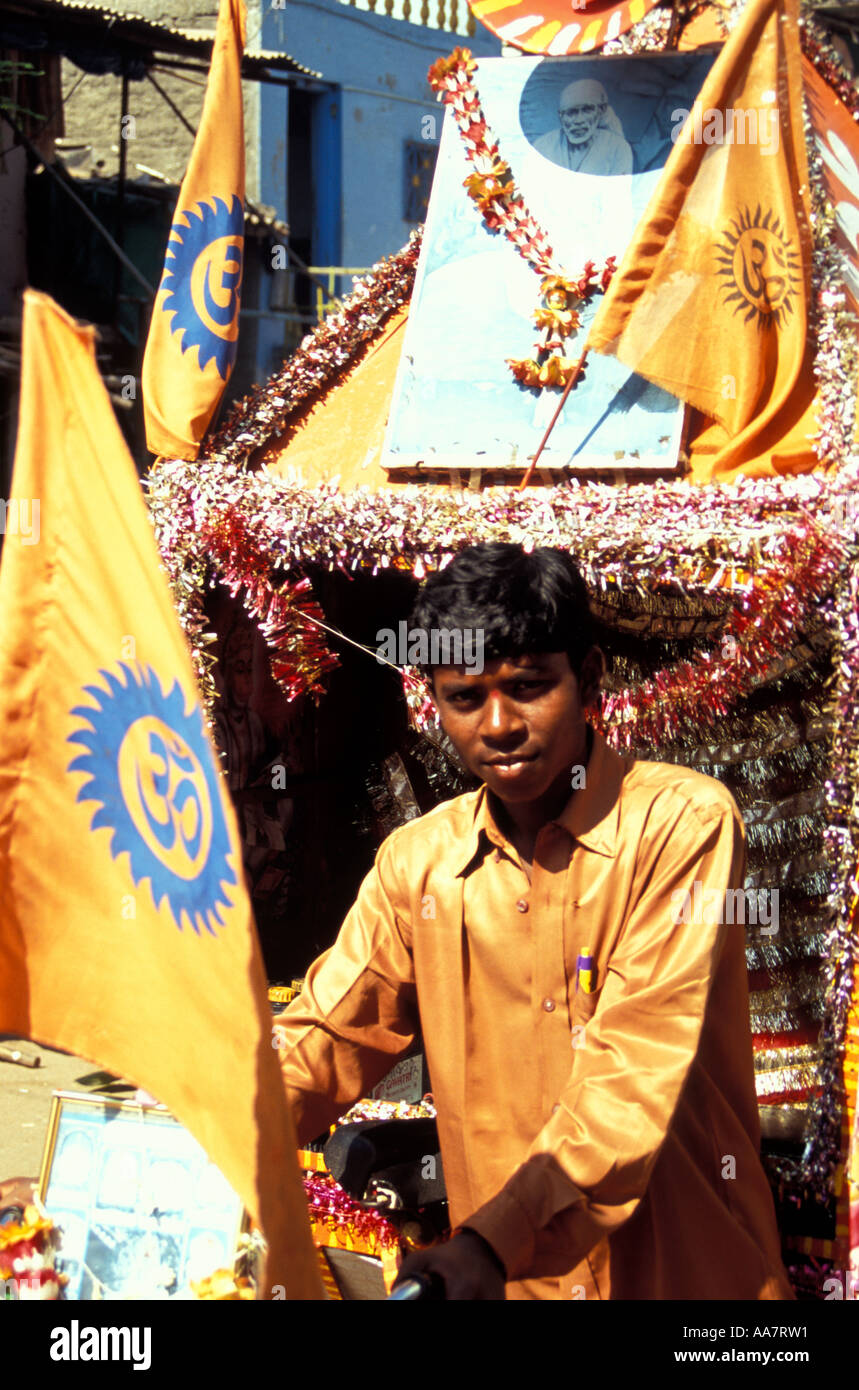 Il devoto indiano di Saint e Fakir Sai Baba di Shirdi che spinge il trolley con i simboli Om, Mumbai, India del Sud Foto Stock