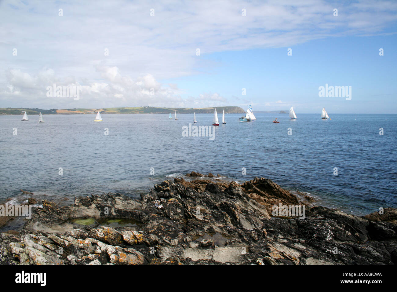 Distante barche a vela in una giornata di sole in Portscatho, Cornwall, Inghilterra Foto Stock