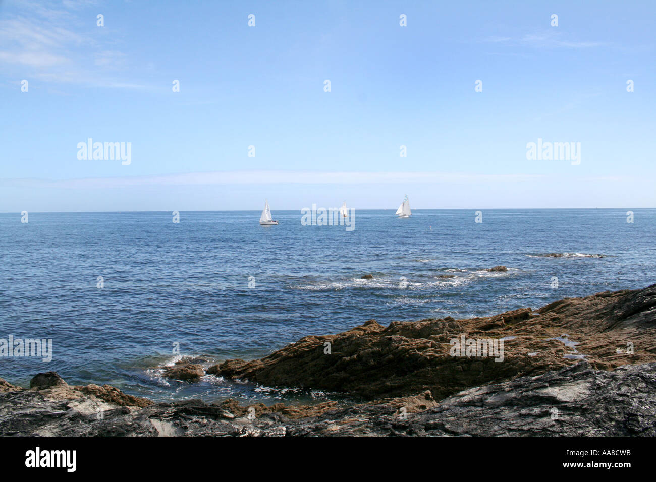 Distante barche a vela in una giornata di sole in Portscatho, Cornwall, Inghilterra Foto Stock
