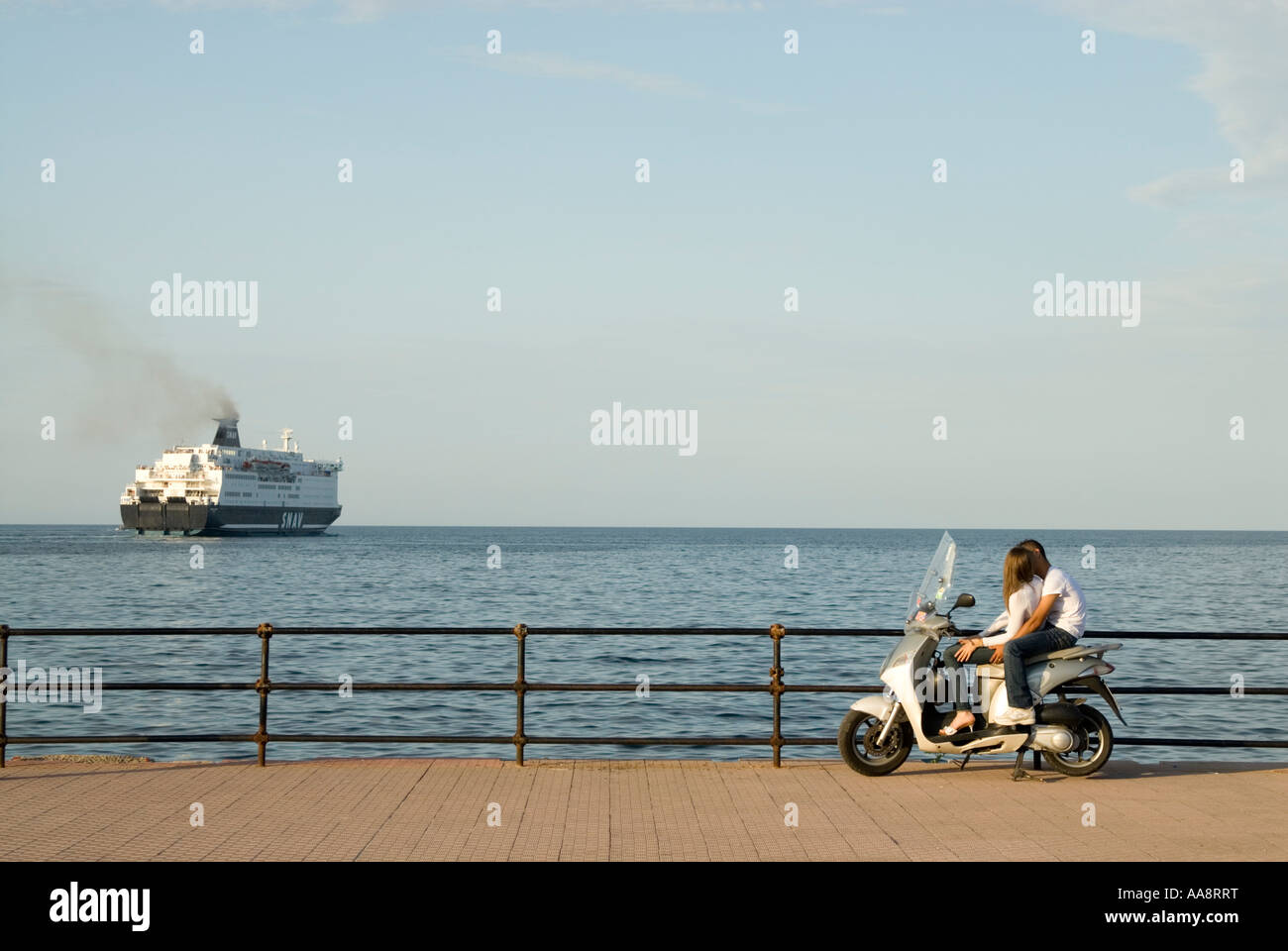 Coppia giovane guardando un traghetto in uscita dal porto di prima serata Palermo, Sicilia, Italia Foto Stock