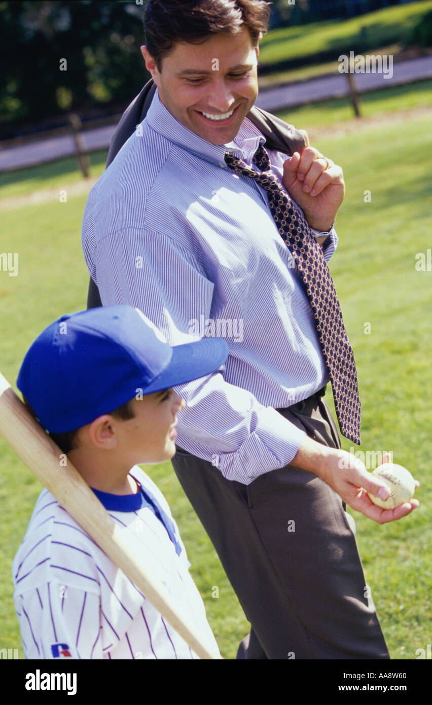 Padre camminando su un prato con suo figlio Foto Stock