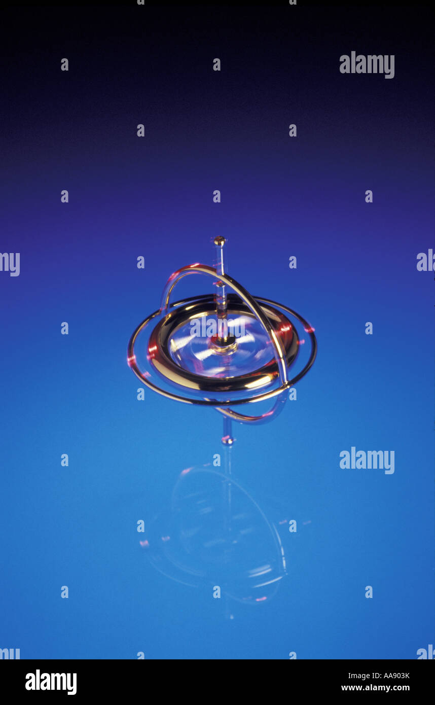 Un giroscopio sempre in posizione eretta per un po' mentre si gira su blu accesa Plexiglas in studio Foto Stock
