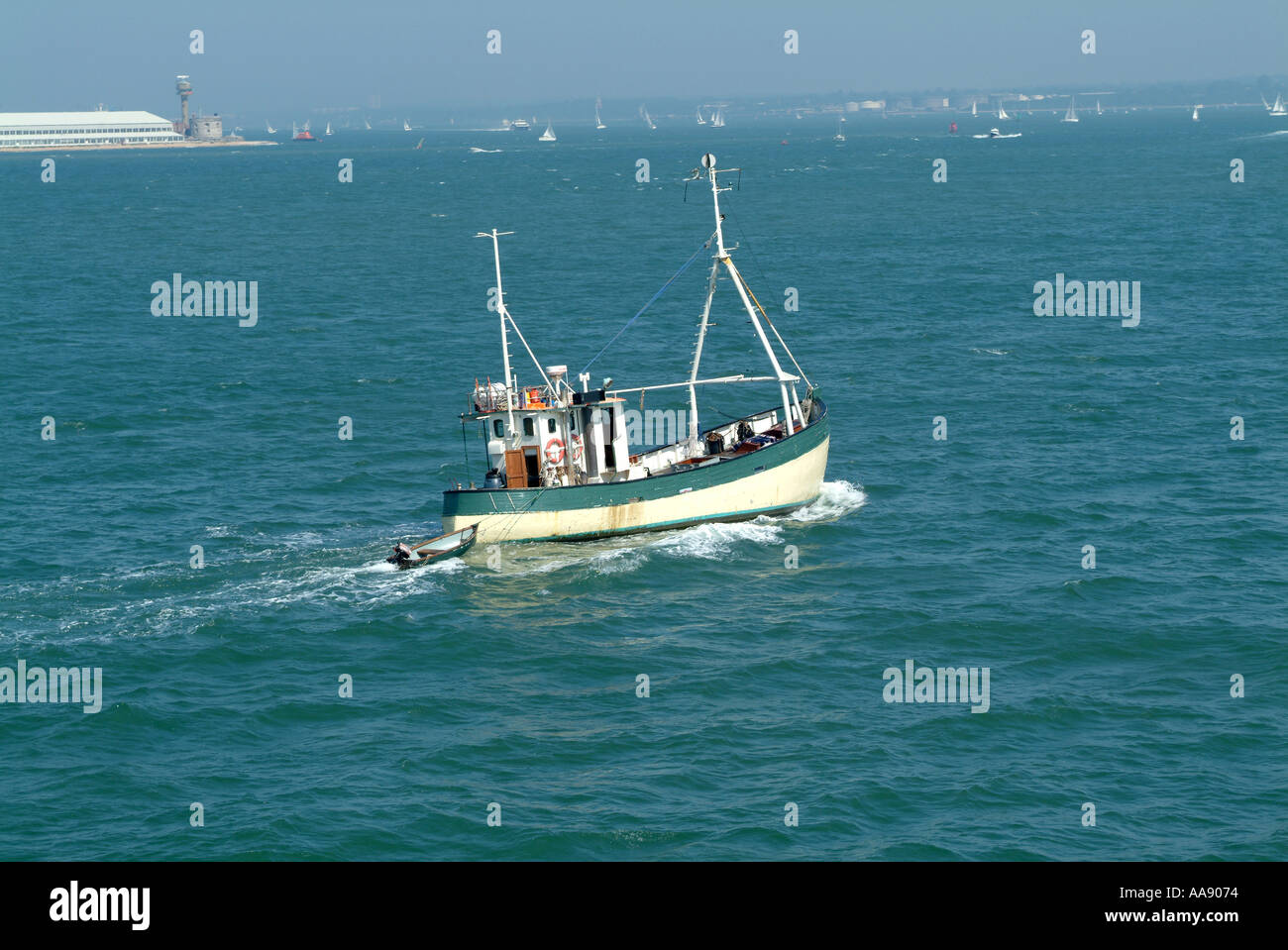 Vecchia barca da pesca il traino di dinghy in Southampton acqua sul Solent Hampshire England Regno Unito Regno Unito Foto Stock