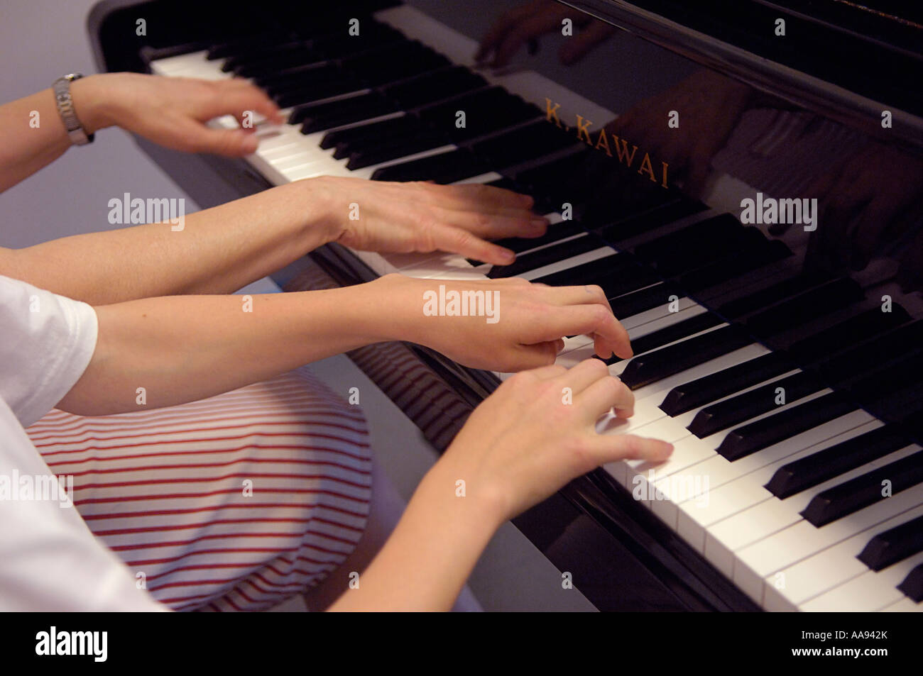 Pianoforte a quattro mani. Un adulto e un adolescente di giocare su un  K.Kawai pianoforte Foto stock - Alamy