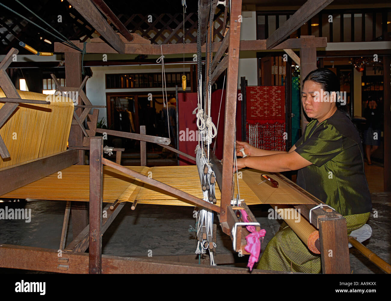 Thai footloom tessitore al suo telaio per la tessitura di fronte di trama del tessuto di mantello di Chiang Mai nel nord della Thailandia Foto Stock