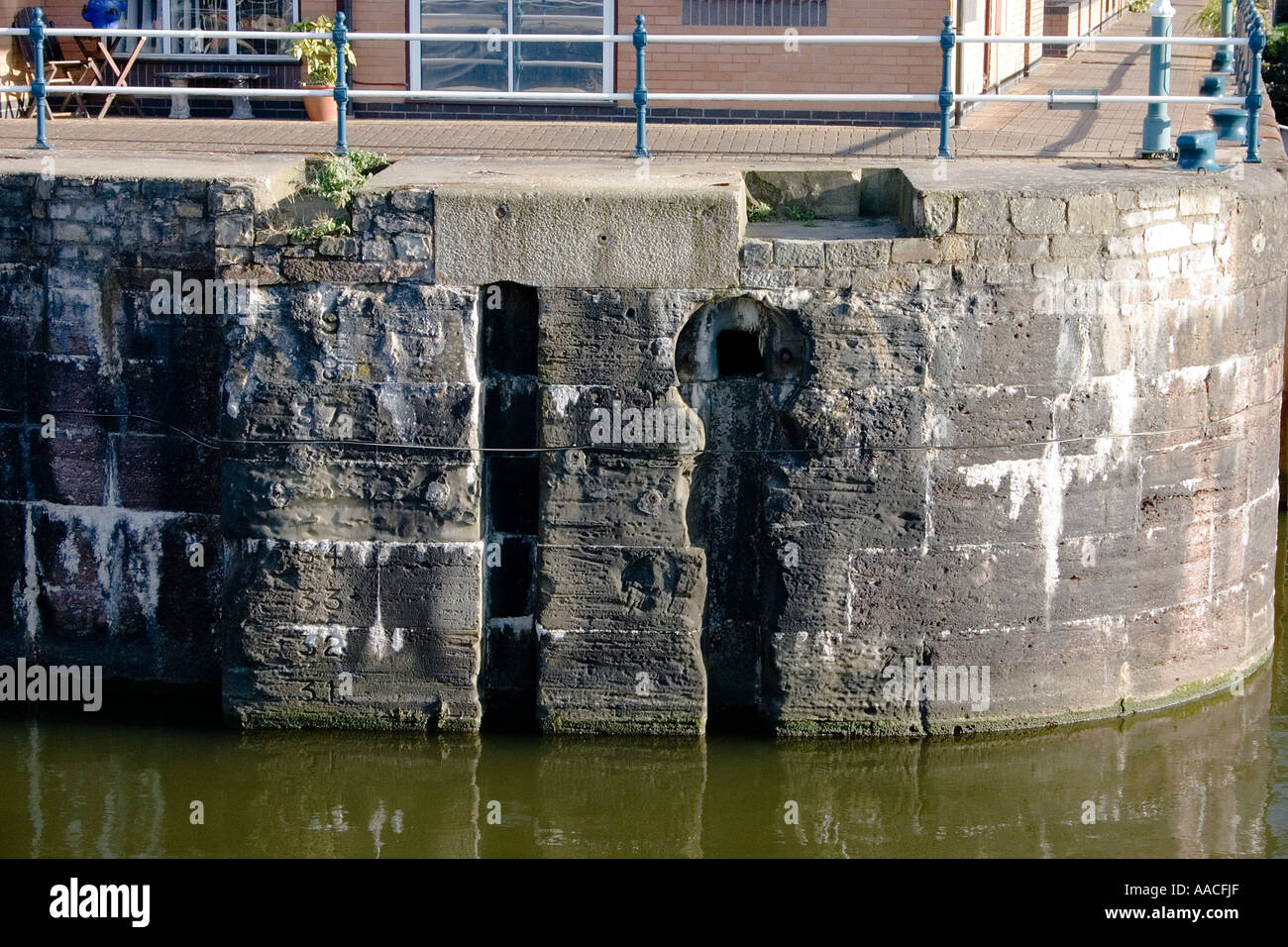 Dock di pietra pareti conformate per e indossato dal vecchio dock gates Penarth Marina S Wales UK Foto Stock