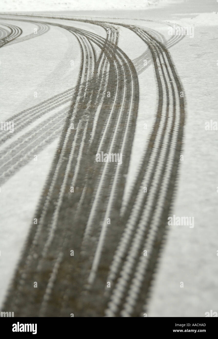 Slidare i segni dei pneumatici in un leggero strato di neve a Tunbridge Wells. Scatto con una profondità di campo bassa, rendendo il primo piano fuori fuoco. Foto Stock