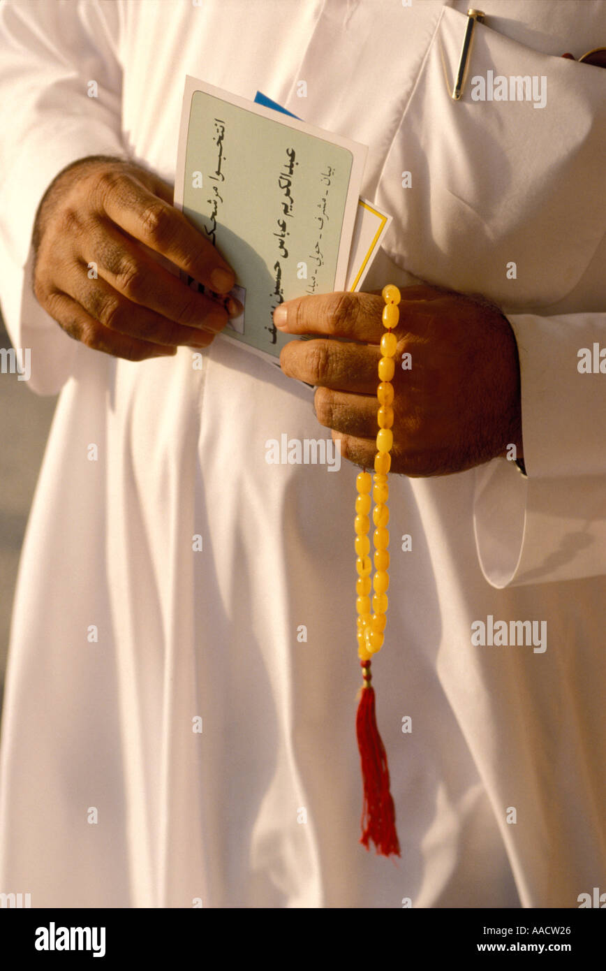 Uomo musulmano in vesti bianche con ambra tradizionali preoccupazioni sfere Kuwait Foto Stock