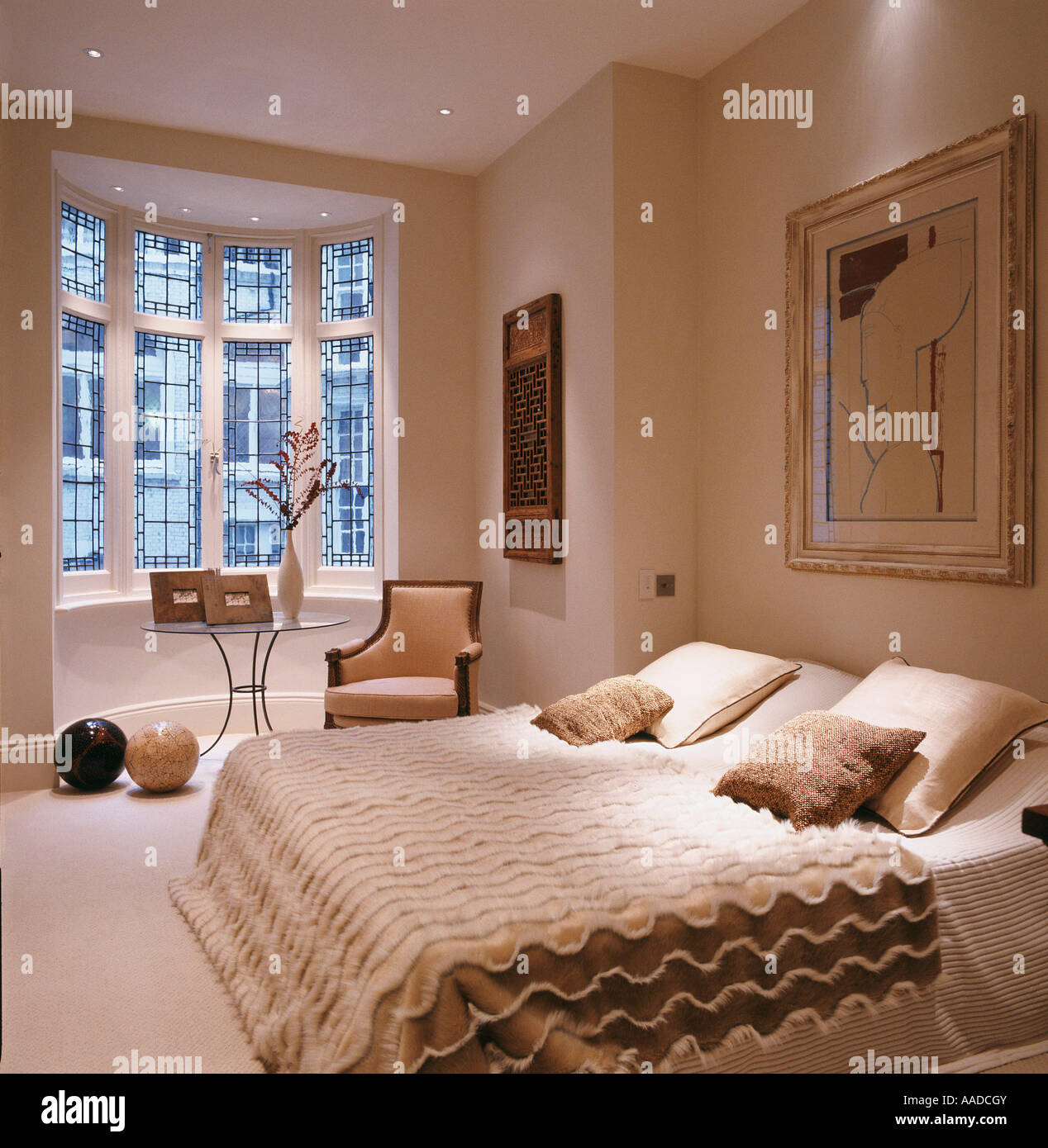 Letto matrimoniale con copertura strutturata in camera da letto color crema  con artwork e finestra Foto stock - Alamy