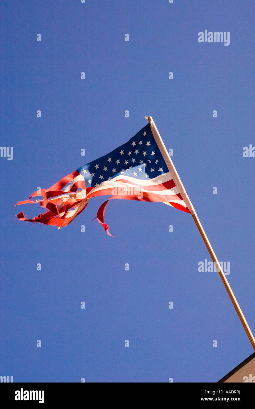 Strappata e strappati dal vento bandiera americana vola da polo in costruzione Foto Stock
