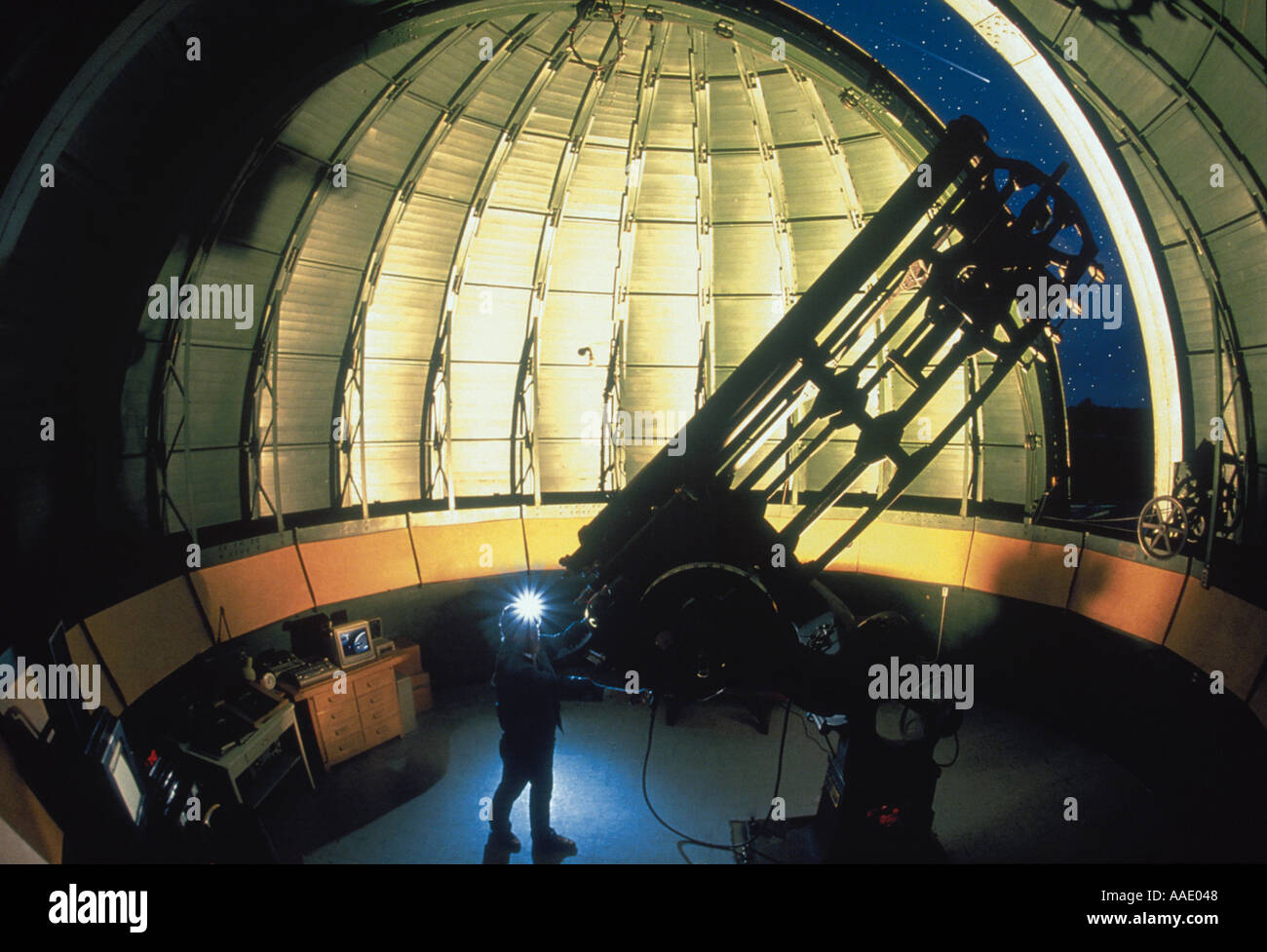 Un astronomo utilizza un classico telescopio per lo studio dei pianeti e stelle da un vecchio osservatorio Foto Stock